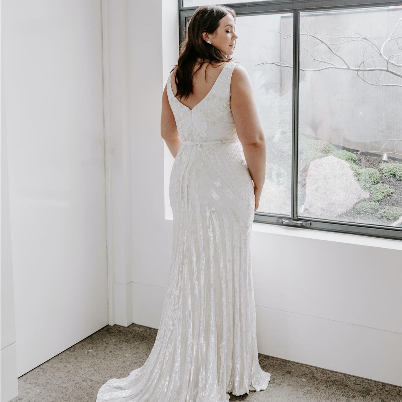 Plus Size Braut in einem Hochzeitskleid in großer Größe mit Schleppe und Rückenausschnitt